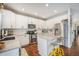 Modern kitchen with white cabinets, granite countertops, and island at 5907 E Tabor Pl, Castle Rock, CO 80104