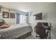 A bedroom features natural light, a bed frame with drawers, and a wall-mounted TV at 20338 E 48Th Dr, Denver, CO 80249