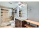 Bathroom with tiled shower, vanity with sink, a large mirror, and built-in shelving at 921 Dakin St, Denver, CO 80221