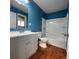 Remodeled bathroom with white vanity, white tile, and wooden floors at 921 Dakin St, Denver, CO 80221
