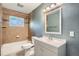 Bright bathroom with a neutral color palette and modern fixtures, including tub and vanity at 921 Dakin St, Denver, CO 80221