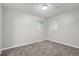 A simple bedroom featuring neutral walls, carpet, and natural light from two windows at 921 Dakin St, Denver, CO 80221