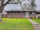 Charming brick home features a well-maintained lawn and mature trees at 921 Dakin St, Denver, CO 80221