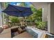 Inviting backyard featuring a deck, lush landscaping, and outdoor seating under a large umbrella at 7630 S Monaco Way, Centennial, CO 80112