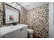 Unique powder bathroom featuring an eye-catching rock wall, floating vanity, and modern fixtures at 7630 S Monaco Way, Centennial, CO 80112