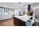 Modern kitchen with white cabinets, stainless steel appliances, and a spacious island with seating at 7630 S Monaco Way, Centennial, CO 80112