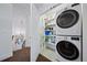 Functional laundry area with stacked washer and dryer, complemented by shelving for supplies at 7630 S Monaco Way, Centennial, CO 80112