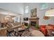 Cozy living room featuring a brick fireplace, comfortable seating, and an adjacent dining area at 7630 S Monaco Way, Centennial, CO 80112