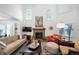 Spacious living room with fireplace, comfortable seating, tall windows, and bright, natural light at 7630 S Monaco Way, Centennial, CO 80112