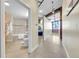 Modern bathroom features a tub/shower combo with beige tiles, a pedestal sink, and exposed brick accents at 2500 Walnut St # 102, Denver, CO 80205