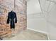 Spacious closet features exposed brick, wire shelving, and a hanging robe for added convenience and charm at 2500 Walnut St # 102, Denver, CO 80205