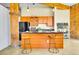 Charming kitchen features light wood cabinets, black countertops, and a breakfast bar with seating at 2500 Walnut St # 102, Denver, CO 80205
