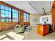 Open living space with exposed brick, industrial lighting, and large windows, leading to a kitchen with modern appliances at 2500 Walnut St # 102, Denver, CO 80205