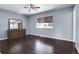 Spacious bedroom with a large window, hardwood floors, ceiling fan and a wooden dresser with mirror at 8030 Ogden St, Denver, CO 80229
