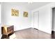 Well lit bedroom featuring hardwood floors, two colorful wall arts, and a wooden dresser at 8030 Ogden St, Denver, CO 80229