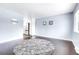 An open living area with dark wood floors and neutral walls, with kitchen in view and ample light at 8030 Ogden St, Denver, CO 80229