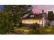 Charming home featuring a manicured lawn, mature trees, and a classic architectural style, enhanced by a vibrant sunset backdrop at 4501 Zenobia St, Denver, CO 80212