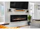 Modern electric fireplace featuring a mounted TV, floating shelves, and live plant at 4501 Zenobia St, Denver, CO 80212