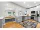 Stylish kitchen featuring gray cabinetry, stainless appliances, hardwood flooring, and a view of the dining area at 4501 Zenobia St, Denver, CO 80212