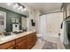 Well-lit bathroom features double sinks, vanity, toilet, shower and tub with decorative wall art at 22342 E Plymouth Cir, Aurora, CO 80016