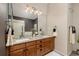 Bathroom with double sinks, wooden cabinets, granite countertop, a large mirror, modern lighting and a walk-in shower at 22342 E Plymouth Cir, Aurora, CO 80016
