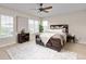 A cozy bedroom features a large bed, ceiling fan, carpet, and natural light from the windows at 22342 E Plymouth Cir, Aurora, CO 80016