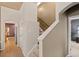 Hallway with staircase and an archway leading to an open kitchen and stainless steel refrigerator at 22342 E Plymouth Cir, Aurora, CO 80016