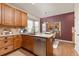 Well-lit kitchen with wood cabinets, stainless steel appliances, granite countertops, and a center island with sink and dishwasher at 22342 E Plymouth Cir, Aurora, CO 80016