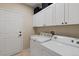 Functional laundry room equipped with a washer, dryer, and ample storage cabinets at 22342 E Plymouth Cir, Aurora, CO 80016