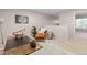 Bright living area features an area rug, comfy orange chair and view into another room at 22342 E Plymouth Cir, Aurora, CO 80016