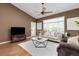 Comfortable living room with hardwood floors, a ceiling fan, neutral furniture, and ample natural light at 22342 E Plymouth Cir, Aurora, CO 80016