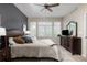 Cozy main bedroom features a dark accent wall, plush bedding, and ample natural light from multiple windows at 22342 E Plymouth Cir, Aurora, CO 80016