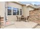 Private outdoor patio with stone accent wall, tile table and comfortable wicker chairs at 22342 E Plymouth Cir, Aurora, CO 80016