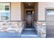 Inviting front entrance featuring a covered porch, stone accents, and a stylish door at 2149 Indian Balsam Dr, Monument, CO 80132