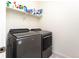 Laundry area featuring front load gray washer and dryer set and a shelf for storage at 2149 Indian Balsam Dr, Monument, CO 80132