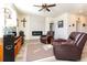 Bright living room featuring modern fireplace, ceiling fan, and two leather armchairs at 2149 Indian Balsam Dr, Monument, CO 80132