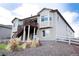 Back of house with a covered wooden deck and manicured stone landscaping leading to backyard at 3910 Mighty Oaks St, Castle Rock, CO 80104