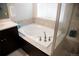 Bright bathroom featuring a soaking tub with a tiled backsplash and modern brushed metal fixtures and glass enclosed shower at 3910 Mighty Oaks St, Castle Rock, CO 80104