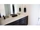 Modern bathroom featuring double sinks, a white countertop, and dark wood cabinetry at 3910 Mighty Oaks St, Castle Rock, CO 80104