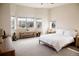 Spacious bedroom with light-colored carpet, three windows with blinds, a Buddha statue, and rustic wood furnishings at 3910 Mighty Oaks St, Castle Rock, CO 80104