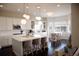 Bright, open kitchen boasts white cabinets, island with seating, stainless appliances, and hardwood floors at 3910 Mighty Oaks St, Castle Rock, CO 80104