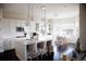 Bright, open kitchen boasts white cabinets, island with seating, stainless appliances, and hardwood floors at 3910 Mighty Oaks St, Castle Rock, CO 80104