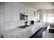 Gourmet kitchen featuring sleek white cabinets, stainless steel appliances, and dark hardwood floors at 3910 Mighty Oaks St, Castle Rock, CO 80104