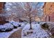 A snow-covered common area showing mature trees and landscaping surrounding the units at 2277 S Buckley Rd # 102, Aurora, CO 80013