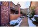View of brick and wood exterior featuring a walkway covered in winter snow at 2277 S Buckley Rd # 102, Aurora, CO 80013