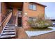 Cozy two-story condo with wood siding, brick accents, and snowy landscaping at 2277 S Buckley Rd # 102, Aurora, CO 80013