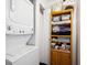 Convenient laundry area with a stacked washer and dryer and storage shelving at 2277 S Buckley Rd # 102, Aurora, CO 80013