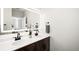Modern bathroom with double sinks, white countertops, and dark wood cabinets at 14353 E 1St Dr # 301, Aurora, CO 80011