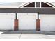 Row of attached garages featuring brick accents and white doors, providing convenient parking and storage at 14353 E 1St Dr # 301, Aurora, CO 80011