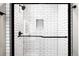 Modern shower featuring a frameless glass door, white subway tiles, and a convenient built-in niche at 14353 E 1St Dr # 301, Aurora, CO 80011